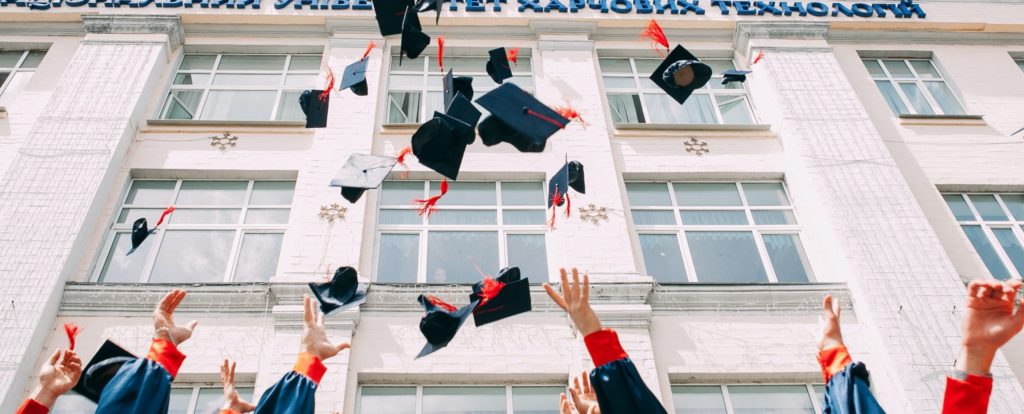 Graduates throwing their caps into the air in celebration